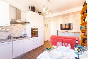 una cucina con armadi bianchi e un divano rosso di Bienvenue à Silvi - la casa accogliente a Silvi Paese