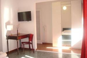 a room with a desk and a television on a wall at Apartment Bruno's in Rome