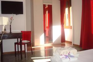 ローマにあるApartment Bruno'sのベッド、デスク、テレビが備わる客室です。