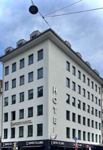a white building with a sign on the side of it at Bayer's City Hotel in Munich