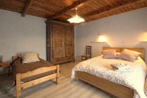 a bedroom with two beds and a wooden cabinet at La Maison de Fernande in Gourgeon