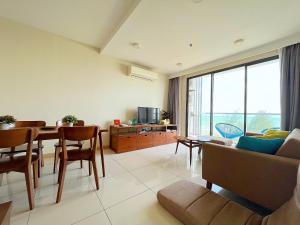ein Wohnzimmer mit einem Tisch und einem Sofa in der Unterkunft Tenang Retreat at Timurbay -Full Sea View- in Kuantan