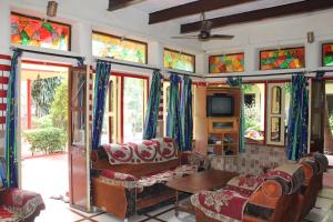een woonkamer met glas-in-loodramen en een bank bij Singh Guest House in Varanasi