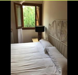 1 dormitorio con 1 cama blanca grande y ventana en Apartamento un dormitorio Los Altos de Escarrilla, FORMIGAL-PANTICOSA, en Escarrilla