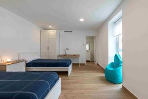 - une chambre avec 2 lits et un bureau dans l'établissement Residencia Demar, à Godella