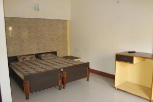 een kleine slaapkamer met een bed en een dressoir bij Singh Guest House in Varanasi
