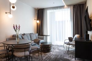 a living room with a couch and a table and chairs at Novotel Living Almaty Jetisu in Almaty