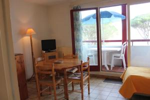 une salle à manger avec une table avec des chaises et un parasol dans l'établissement Vacances à Bidart-Plage, à Bidart