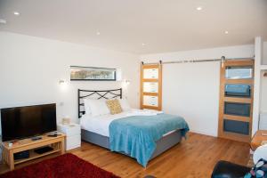 a bedroom with a bed and a flat screen tv at Croft 7 Geary Self Catering Studio with stunning sea views in Geary
