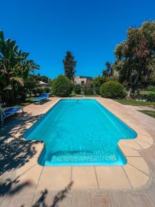 una piscina de agua azul en un patio en Tra Terra e Mare, en Flumini di Quartu