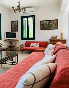 a living room with a red couch and a table at Temenia House in Teménia