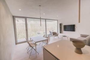 uma sala de estar com uma mesa e cadeiras e um sofá em STEILLAGE - Design Moselsuiten mit Panoramablick und SPA em Brauneberg