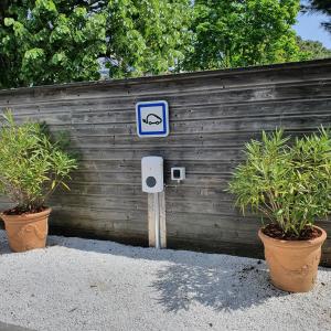 un panneau bleu devant une clôture avec deux plantes dans l'établissement Logis Hotel La Closerie, à La Baule