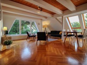 a living room with wood floors and a table and chairs at Ferienhaus Makrele von 1877 in Stahlbrode