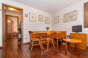 a dining room with a table and chairs and a television at Condominio Le Marmotte in Selva di Cadore