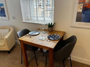 a wooden table with two chairs and wine glasses at Wenden Guest House in Newquay
