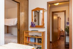 a bedroom with a bunk bed and a mirror at Condominio Le Marmotte in Selva di Cadore