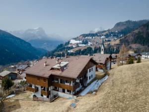 a building on top of a hill with a town at Condominio Le Marmotte in Selva di Cadore