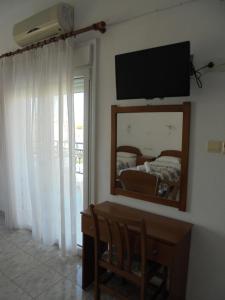 利邁納里亞的住宿－Villa Chrissa，一间带镜子、一张桌子和一张床的卧室