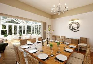 a dining room with a long table and chairs at Torbay Rise sea side villa with family facilities in Torquay