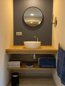 a bathroom with a sink and a mirror at De oude es in Bocholt