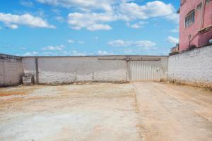 an empty building with a gate and a wall at OYO M&J Hotel in Santo Antônio do Descoberto