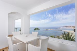 a white dining room with a view of the ocean at B51 Executive Flats Marbella in Marbella