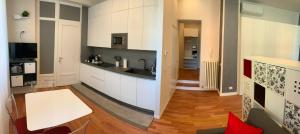 a kitchen with white cabinets and a white table at Miralago in Como