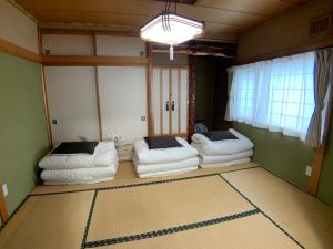uma sala de estar com dois sofás brancos num quarto em TY-Home em Asahikawa