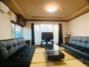 a living room with a couch and a tv at TY-Home in Asahikawa