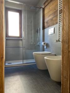 a bathroom with a shower and a tub and a toilet at Fraiteve Suite in Sauze dʼOulx