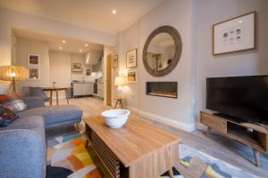 a living room with a couch and a tv at Howe Keld 1 Ground floor in Keswick