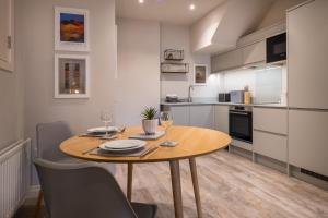 a kitchen with a wooden table with wine glasses at Howe Keld 1 Ground floor in Keswick