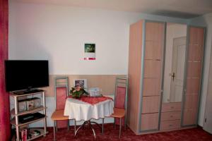 a room with a table with chairs and a tv at Pension Hackbarth in Beilngries