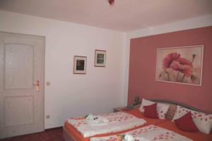 um quarto com uma cama e uma parede vermelha em Pension Hackbarth em Beilngries