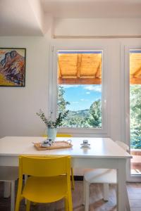 a dining room with a white table and yellow chairs at La Casa nell'Oliveto a San Martino in Monreale