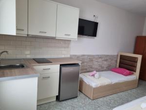 eine kleine Küche mit einem kleinen Bett in einer Küche in der Unterkunft Anna Christina Apartments in Metamorfosi