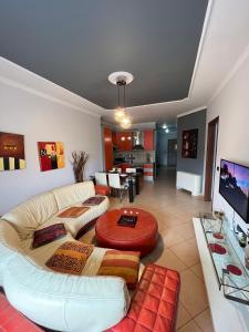 ein Wohnzimmer mit einem Sofa und einem TV in der Unterkunft Skanderbeg Square EXPLORER APARTMENTS in Tirana