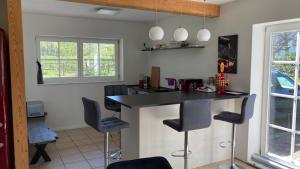 a kitchen with a black counter and bar stools at Ferienhaus Spreewald direkt am Wasser in Burg Kauper