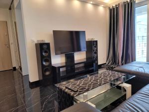 a living room with a flat screen tv and speakers at Apartamenty Tenisowa in Szczecin