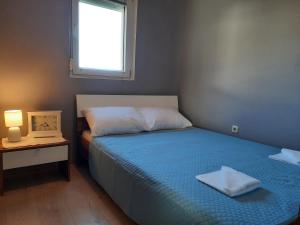 um pequeno quarto com uma cama e uma janela em Apartment Dominik-Posedarje em Posedarje