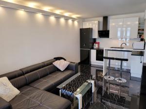 a living room with a couch and a kitchen at Apartamenty Tenisowa in Szczecin