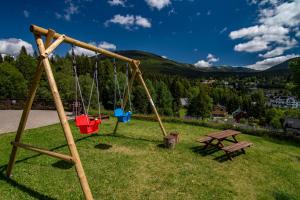 einen Park mit einer Schaukel und einem Picknicktisch in der Unterkunft Pension Aspen in Špindlerův Mlýn