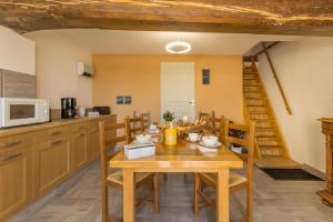 uma cozinha e sala de jantar com uma mesa de madeira e cadeiras em Les Pâtis 