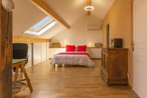 a bedroom with a bed with red pillows at Les Pâtis in Châtellenot