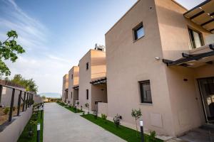 a row of buildings with a sidewalk next to it at Serenity Suites Sea View Houses - Happy Rentals in Káto Xirokhórion