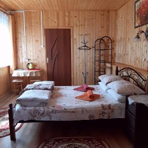 a bedroom with two beds in a room with wooden walls at Shanson in Gagra