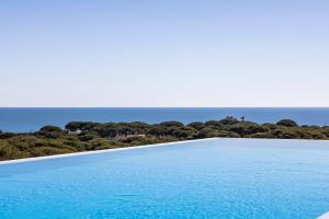 a swimming pool with the ocean in the background at Vila Maria Hotel - Adults Only in Albufeira