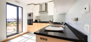 a kitchen with a sink and a large window at CASA AURA in Olhão