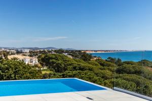 a villa with a swimming pool and a view of the ocean at Vila Maria Hotel - Adults Only in Albufeira